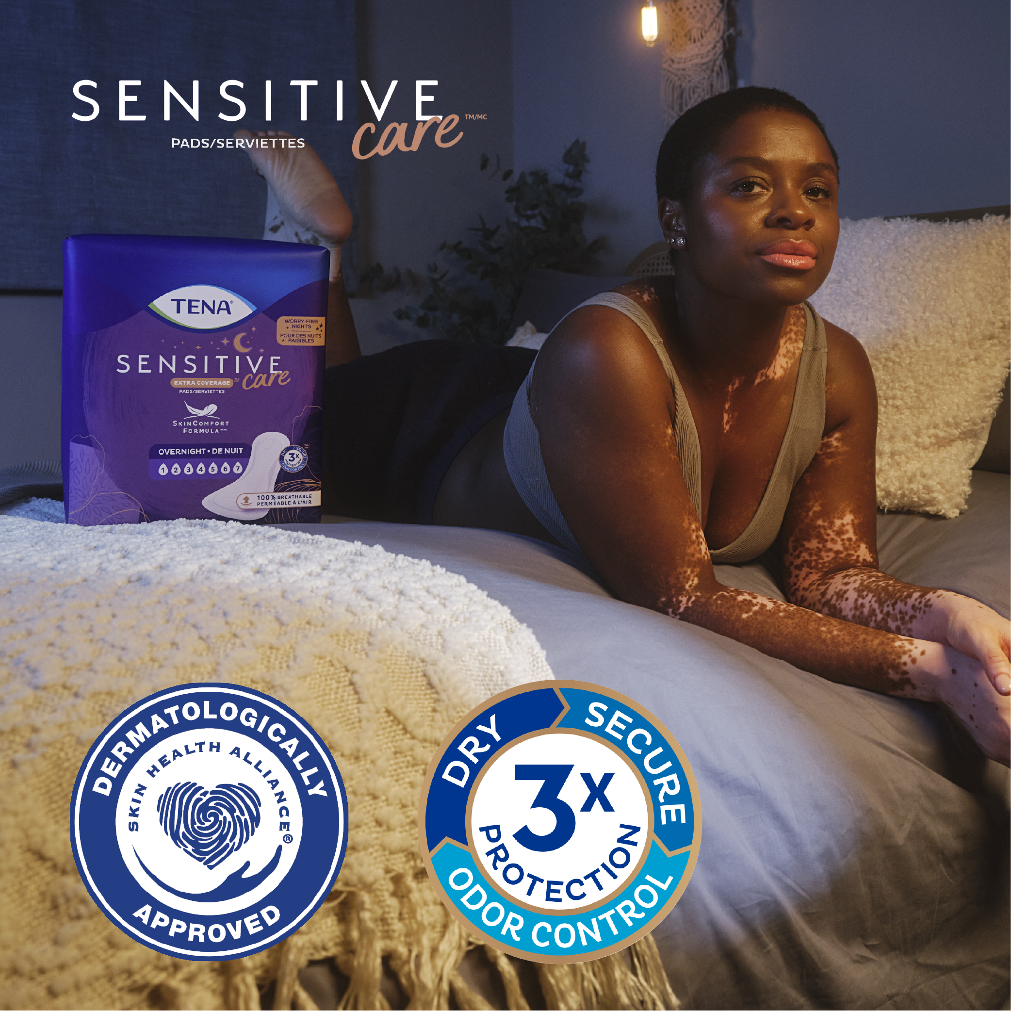 A woman lays on the bed with a package of overnight pads A woman lays on the bed with a package of overnight pads